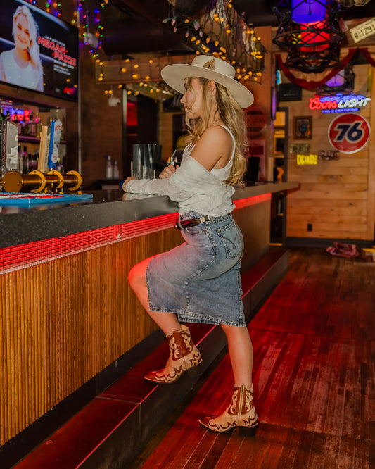 Madeleine wearing Cruel Denim midi skirt, Roper blouse, Stetson hat and boots, topped with Tony Lama belt and STS Ranchwear purse