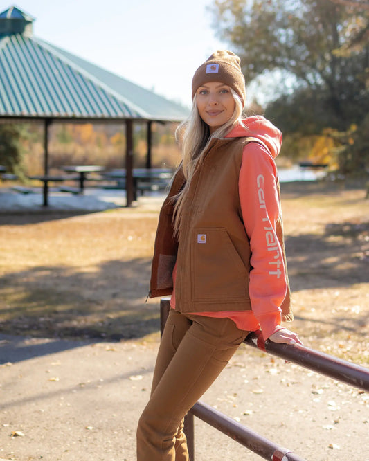 Michelle, model, styled in Carhartt hi‑vis chore jacket on jobsite with western boots