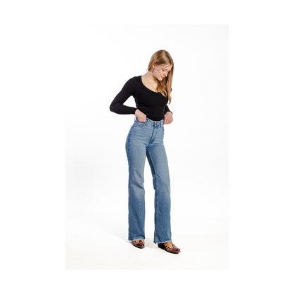 Woman wearing blue jeans and a black top on a white background